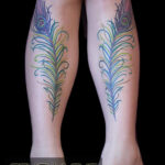 Matching peacock feather leg tattoos